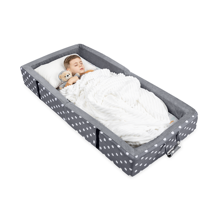 A Toddler Hugging a Teddy Bear While Sleeping on a Gray Milliard Toddler Travel Bed
